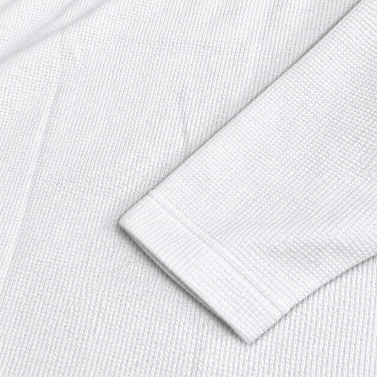 Gros plan de la finition de manche et de la texture waffle du maillot JT Racing blanc