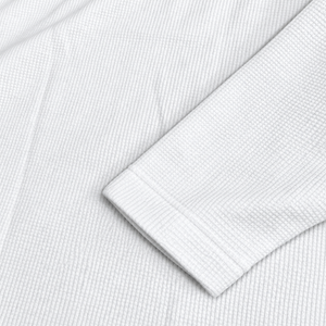 Gros plan de la finition de manche et de la texture waffle du maillot JT Racing blanc